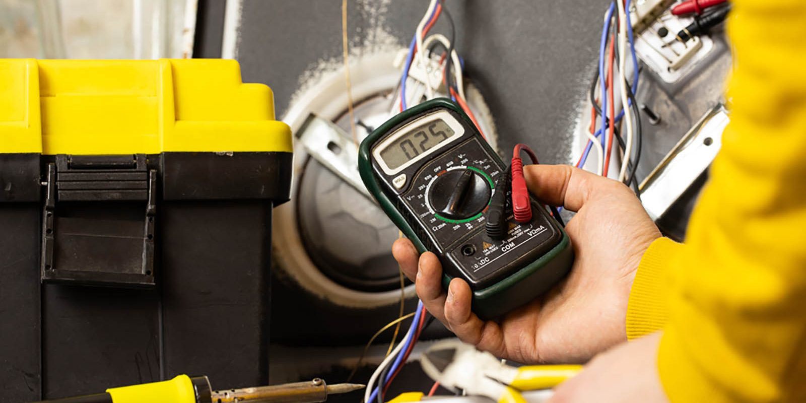 A close up view of an electrician holding a voltmeter