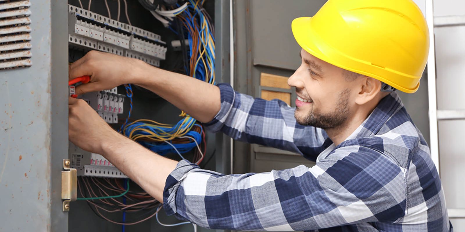 Electrician working on an industrial fusebox