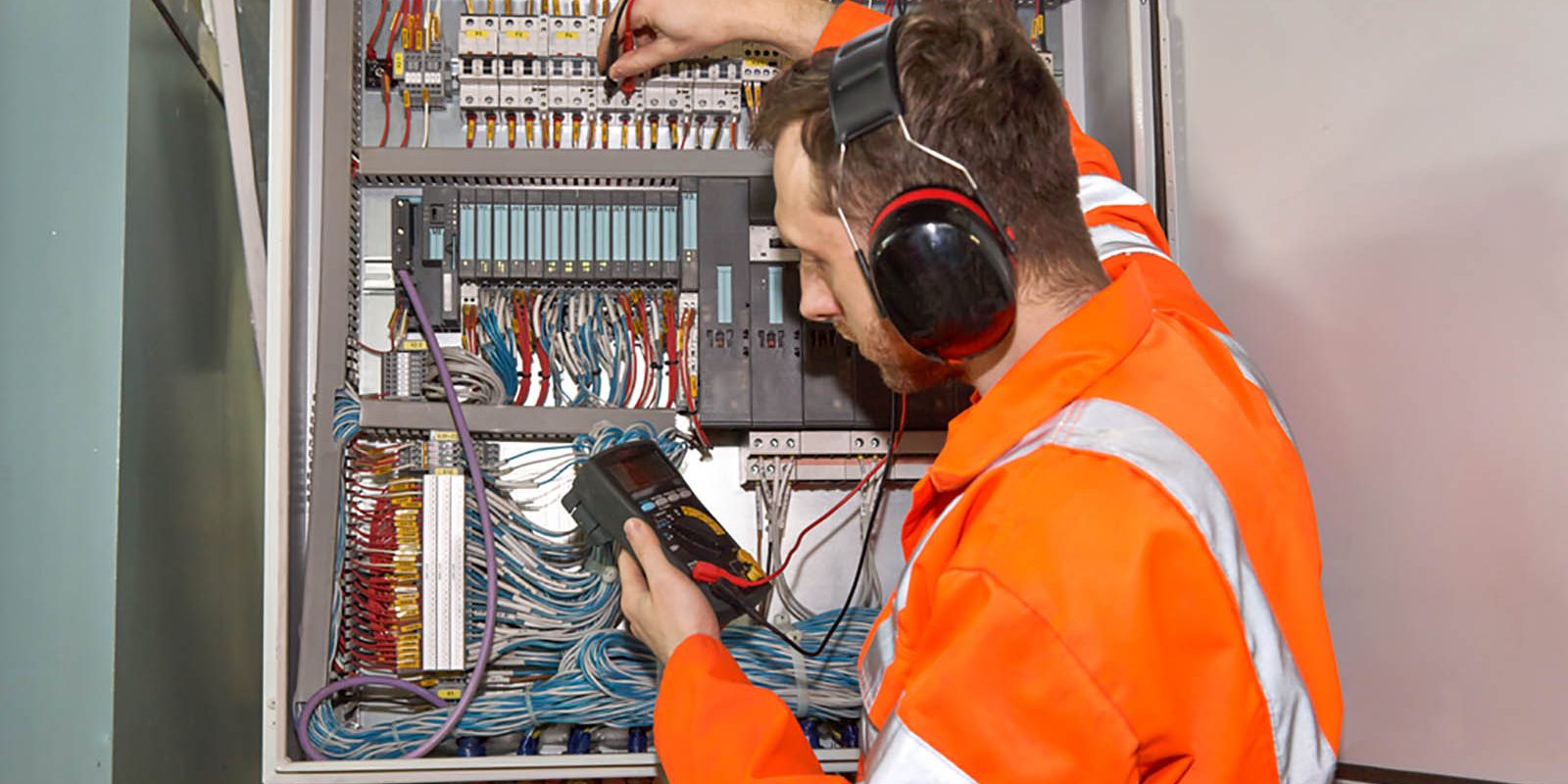 An Electrician using a voltmeter