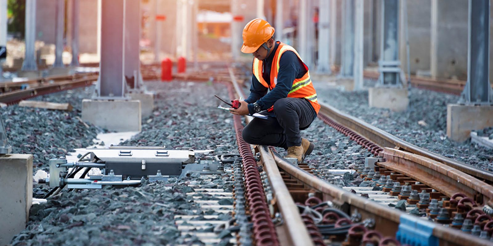 A worker inspecting railway tracks