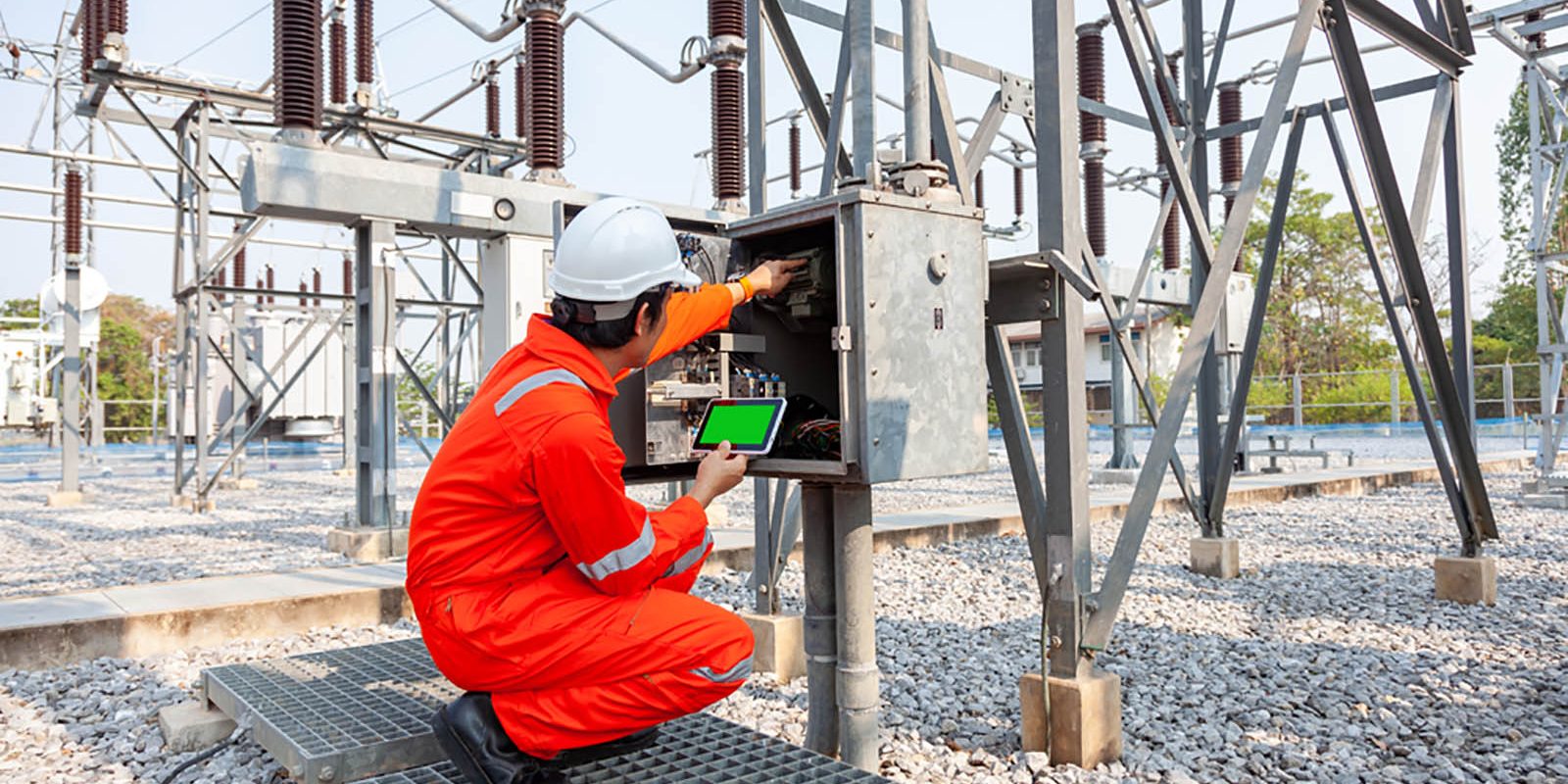 An electrician working at an electrical substation